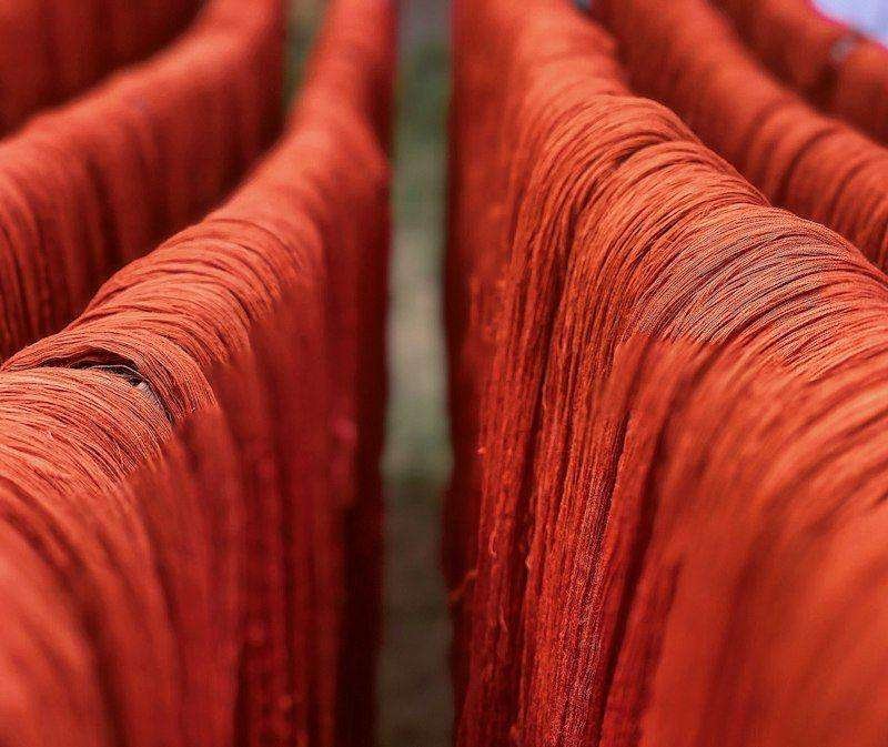Illustrative image: skeins of red dyed thread