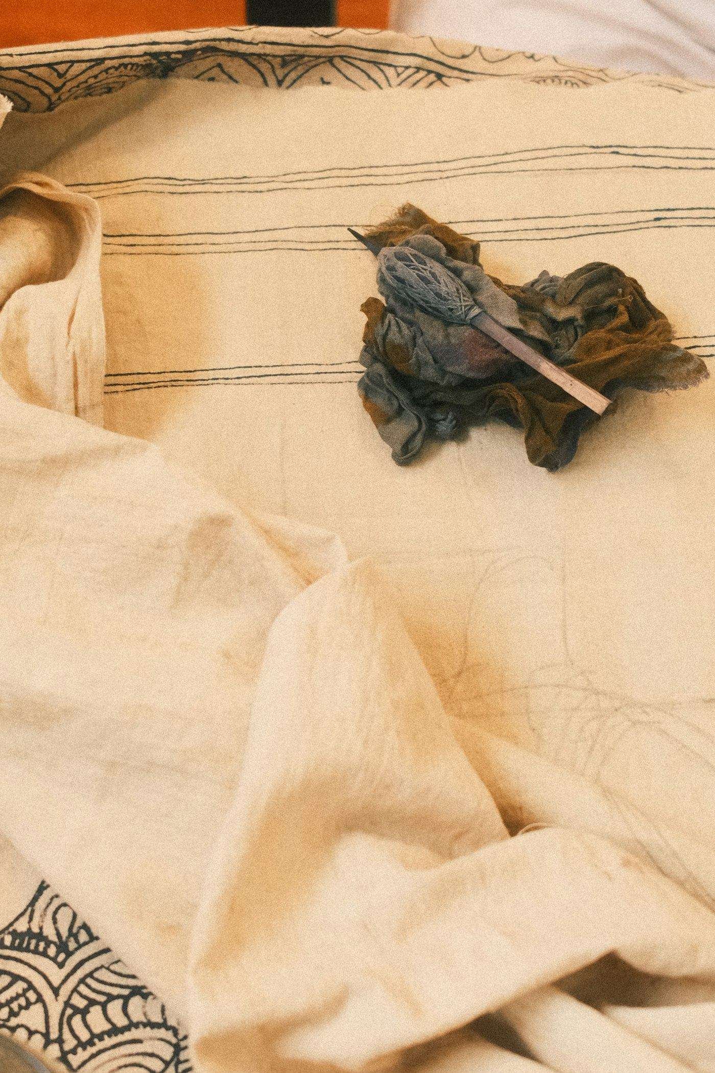Illustrative image: bundled cotton fabric with a wooden printing tool