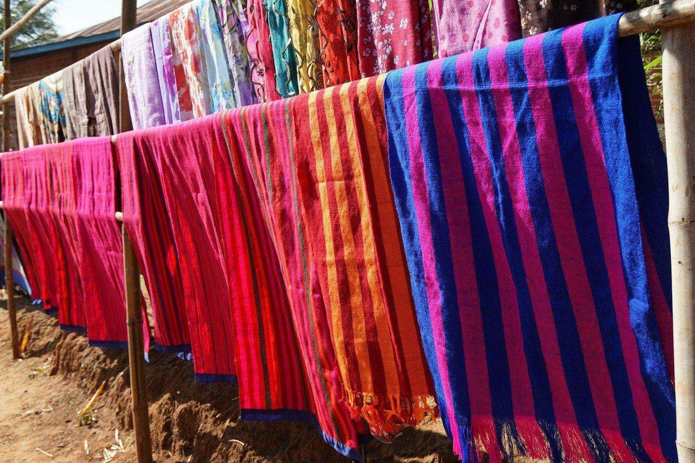 Illustrative image: colourful fabrics drying on lines in the sun