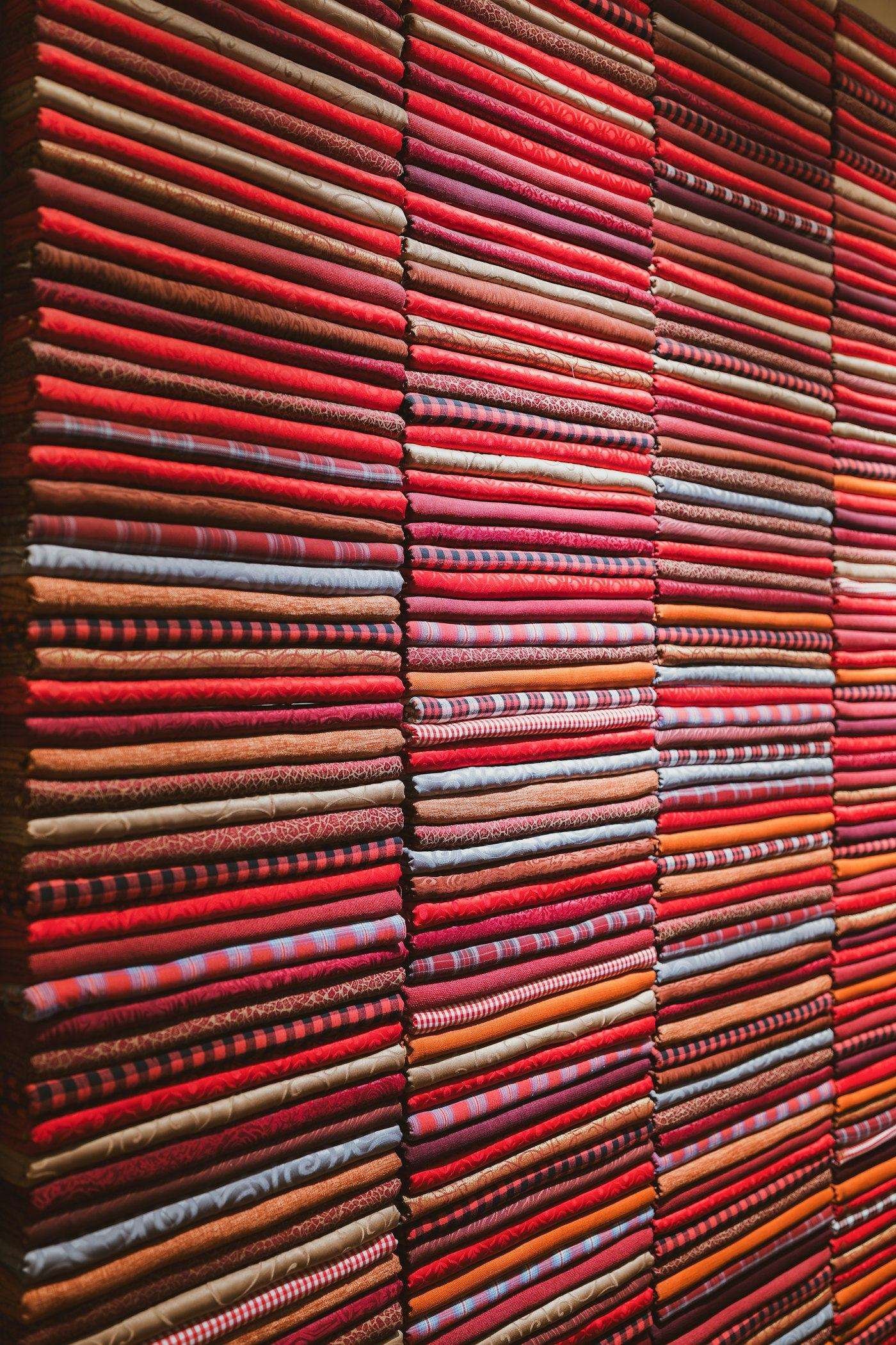 Illustrative image: stacks of folded fabric in red and orange