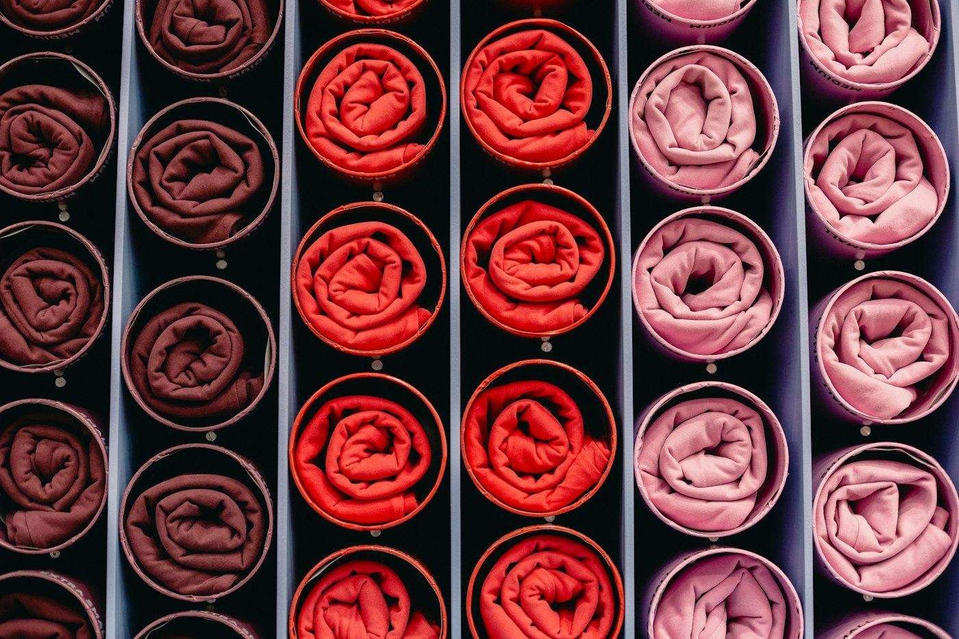 Illustrative image: rolled fabric swatches in shades of red and pink