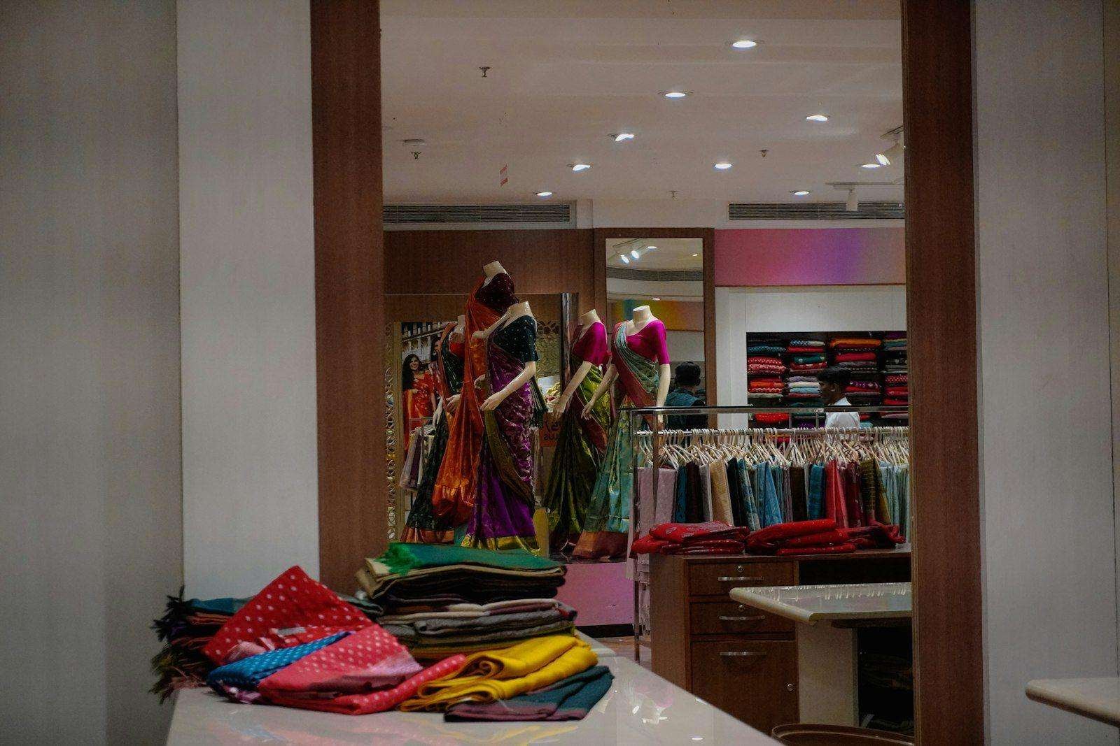 Illustrative image: sarees displayed on mannequins inside a store