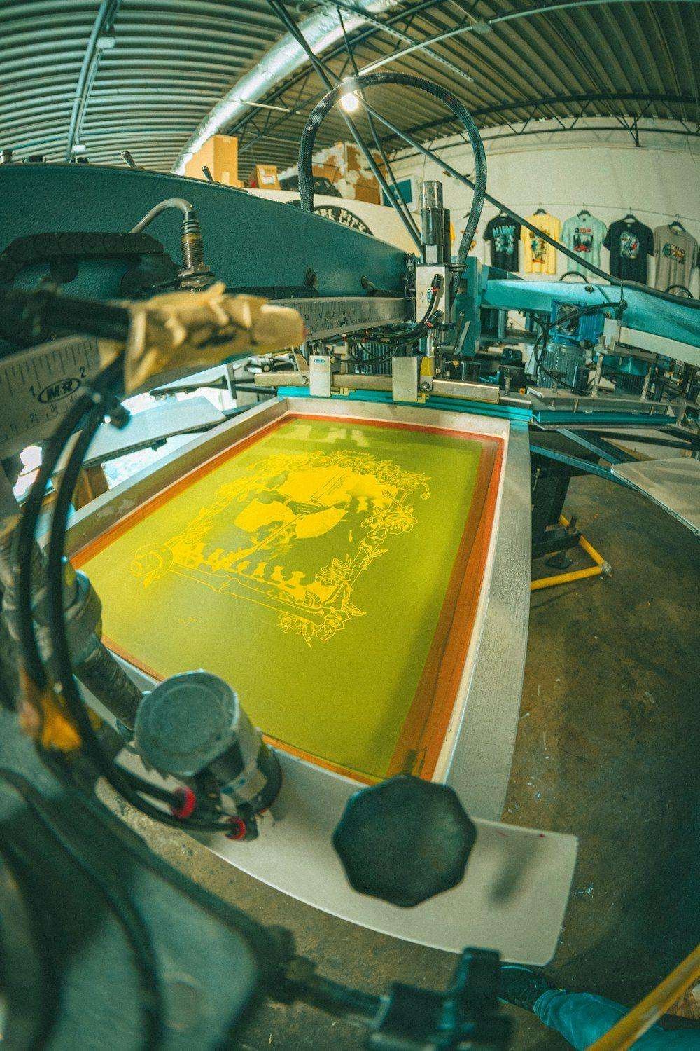 Illustrative image: screen printing machine applying yellow ink